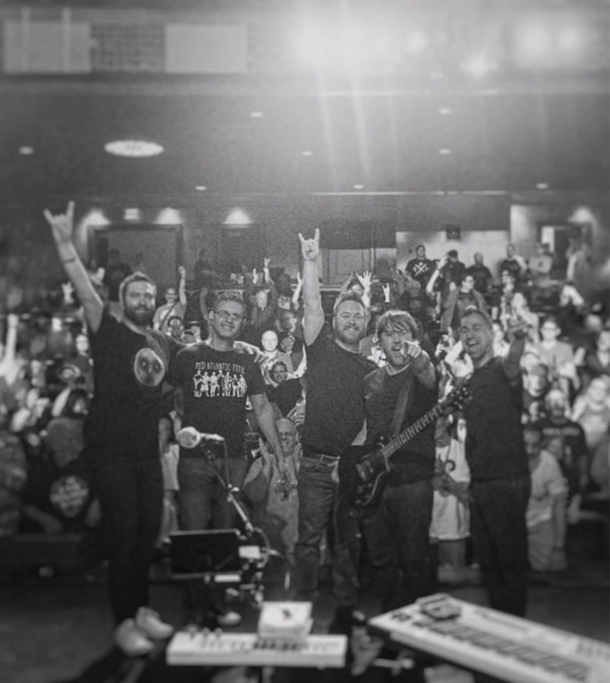 Image may contain: 5 people, people smiling, crowd