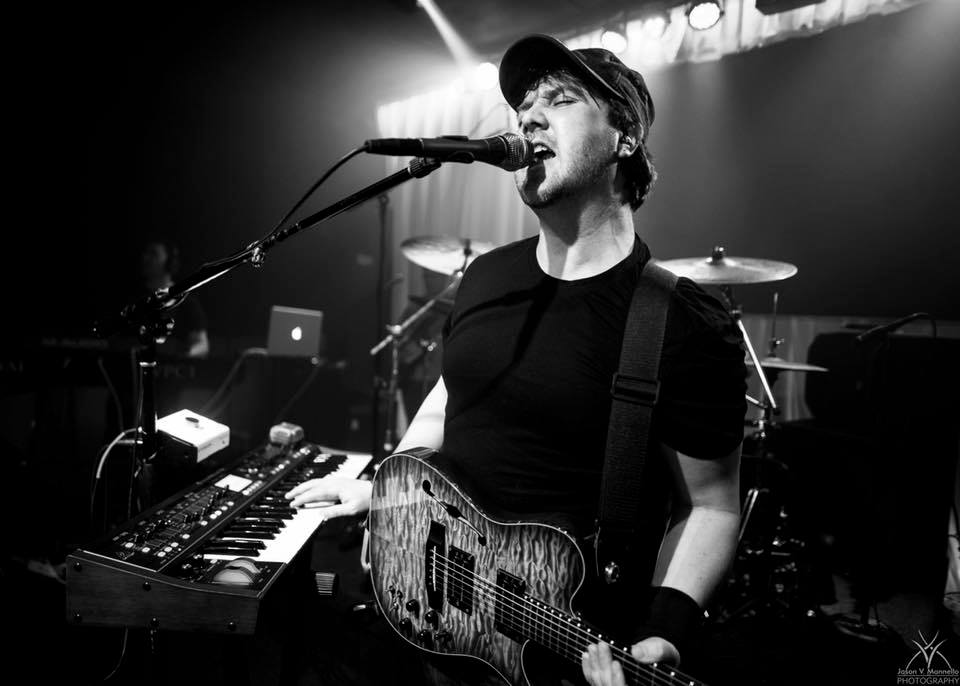 Image may contain: 1 person, on stage, playing a musical instrument, concert, guitar and night